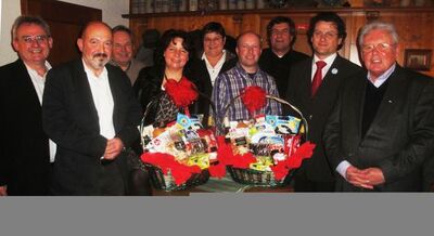 Gruppenbild mit den beiden Geehrten Dr. med. Hans Schwarz und Diplom-Ingenieur Josef Holler (neben den Geschenkkörben)